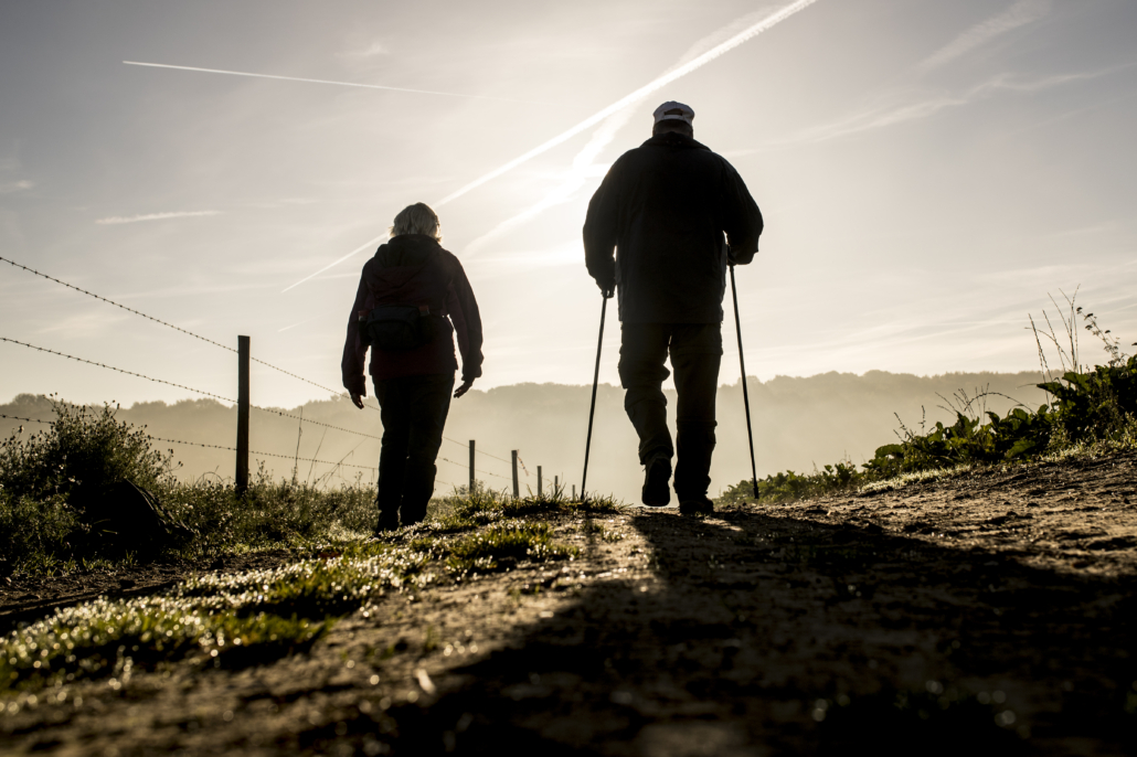 Twee wandelaars op veldweg met mistig landschap op de achtergrond